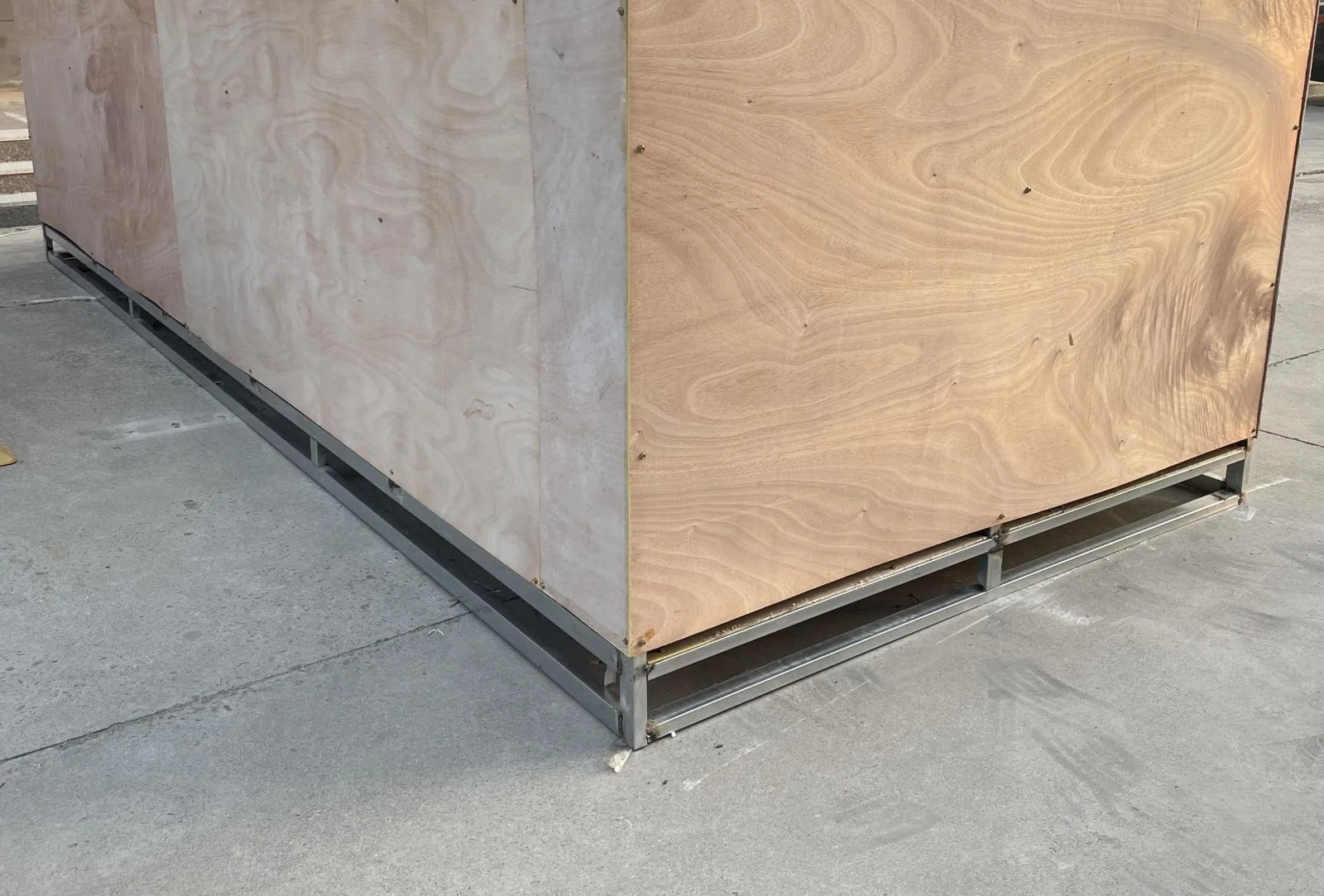Wooden shipping crate supported by a metal base